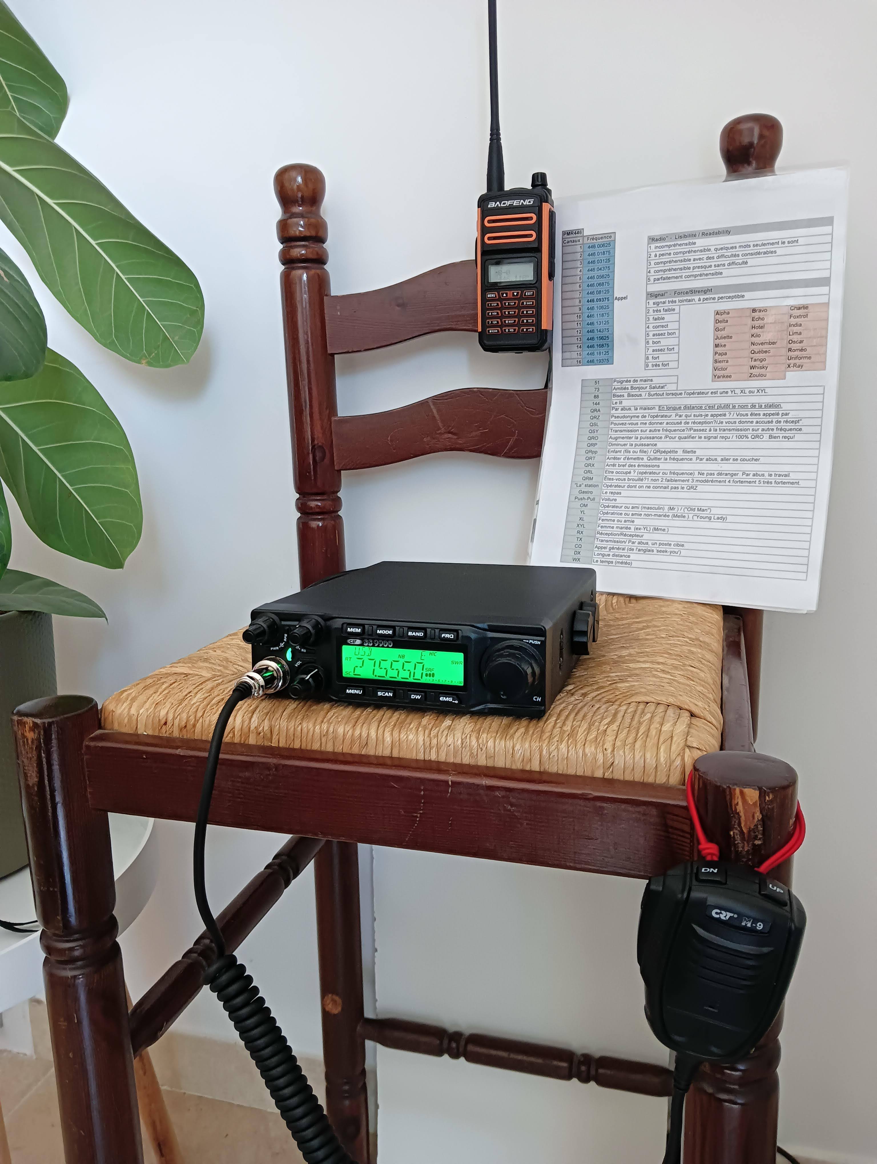 Une chaise haute, avec la radio posée et un portatif accroché sur le dossier