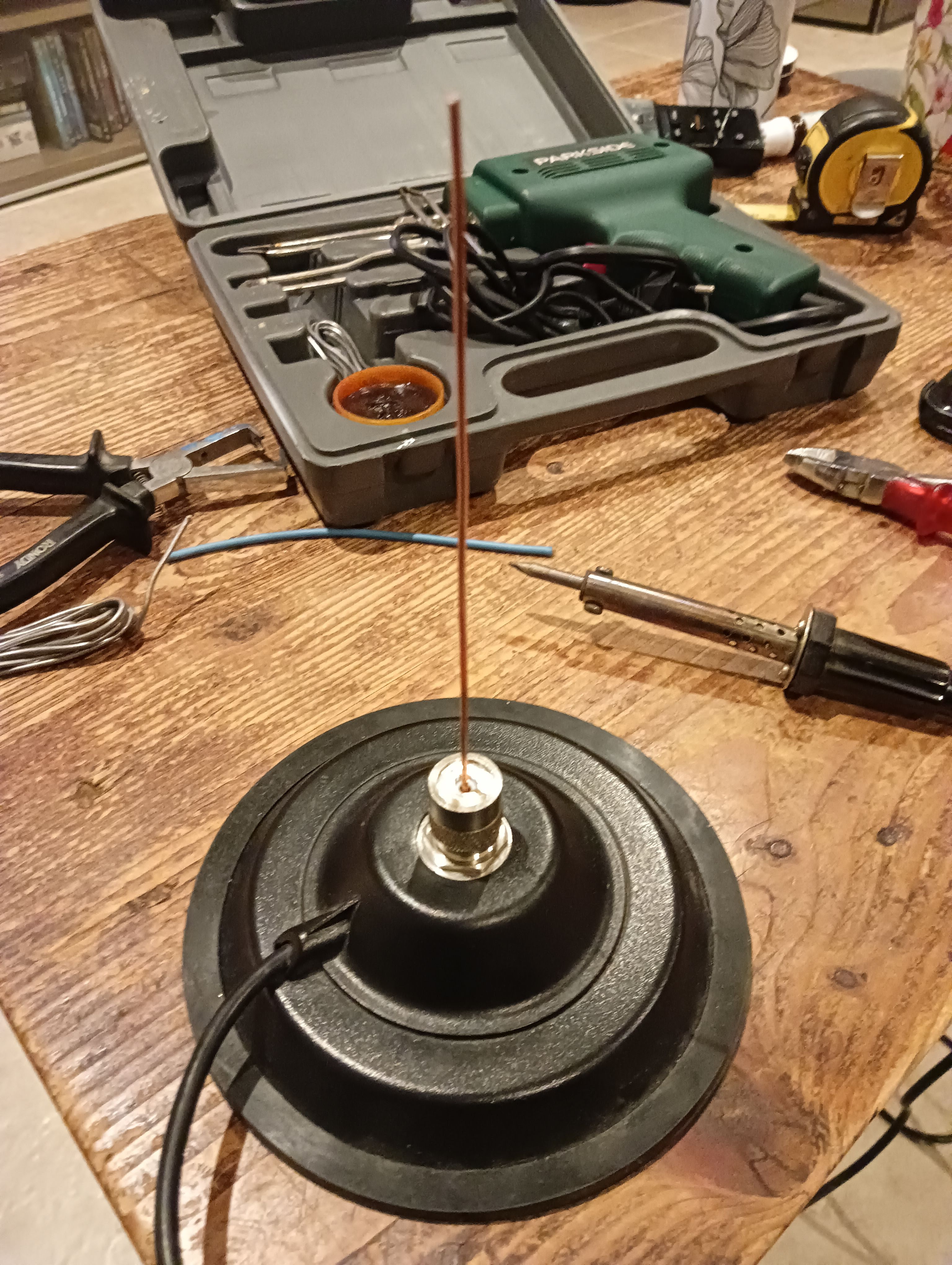 Le quart d'onde, branché à une embase magnétique, sur la table basse en bois du salon.